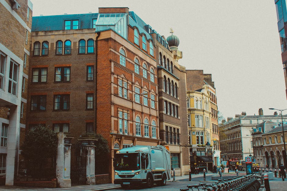 A street scene in Brixton Myatts Fields featuring a mix of historic brick and ornate yellow buildings with large sash windows, some topped with decorative architectural details and domes. The street i